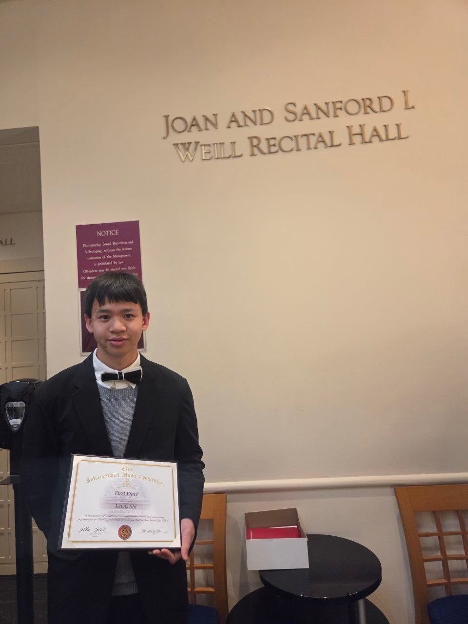 Student holding First Place certificate outside Weill Recital Hall at Carnegie Hall