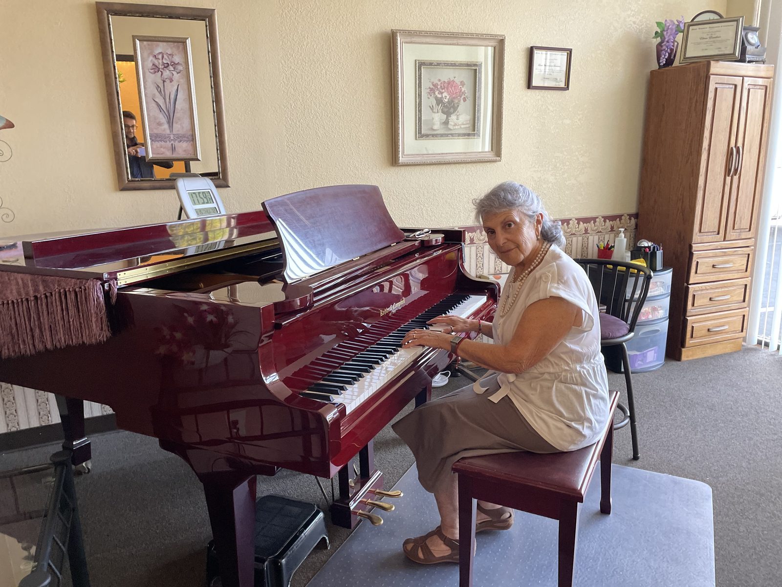 Dina Reznik playing grand piano in her studio