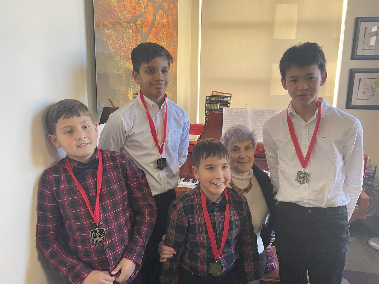 Dina Reznik with four students wearing music medals
