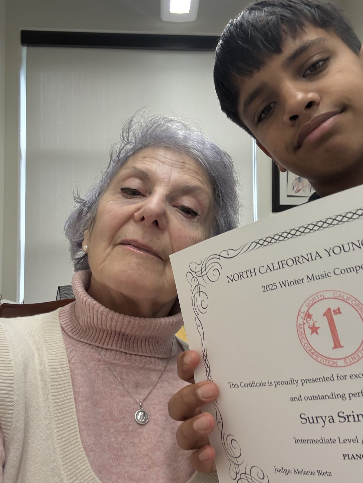 Dina Reznik with a student holding a first place certificate